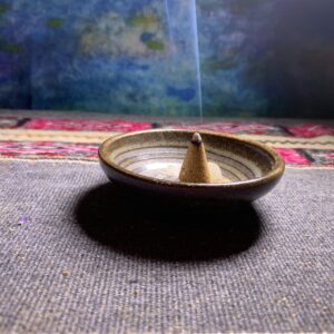 palo santo on an indigenous cloth that is lit with smoke coming out